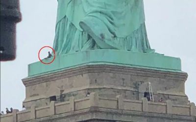 Woman climbs onto the base of Statue of Liberty protesting Trump immigration policy
