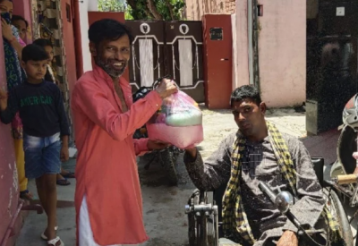 Specially-abled man distributes ration and masks with money he collected by begging