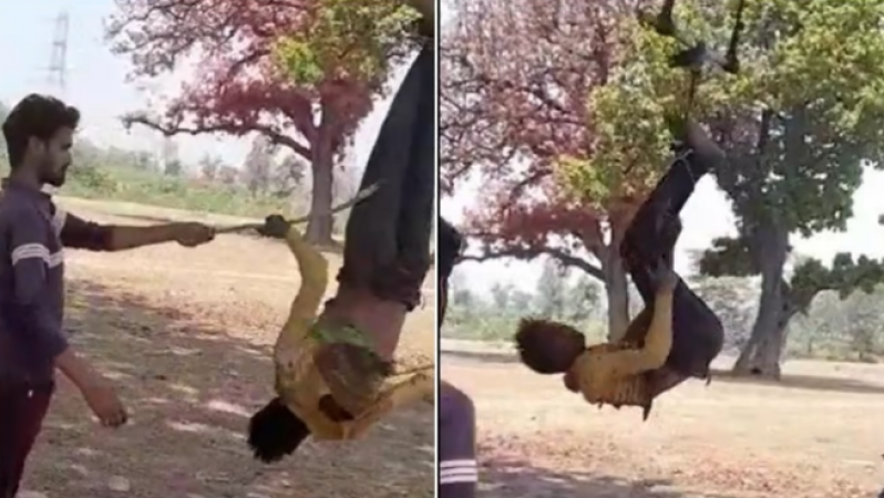 5 people hang young man upside down from tree