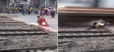 VIDEO: बंद फाटक को पार करने निकला बाइक सवार, रेलवे ट्रैक पर मरते-मरते बचा