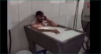 दूध से नहा रहा है कर्मचारी, वीडियो हुआ वायरल